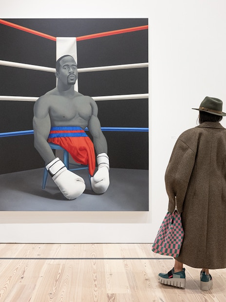 Visitor viewing Amy Sherald painting of a boxer at Whitney Museum of American Art.