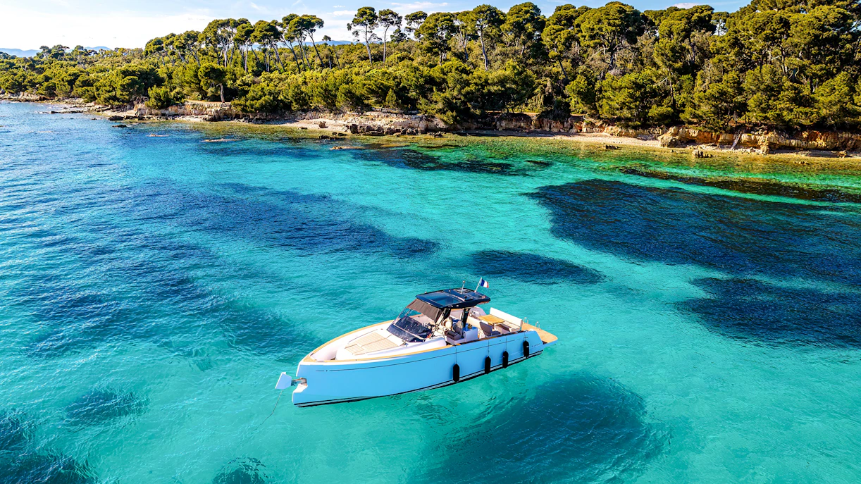 Private boat on turquoise waters near Lérins Islands, Cannes.