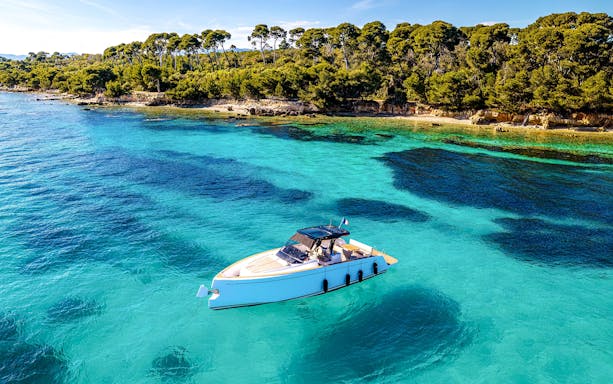 Private boat on turquoise waters near Lérins Islands, Cannes.