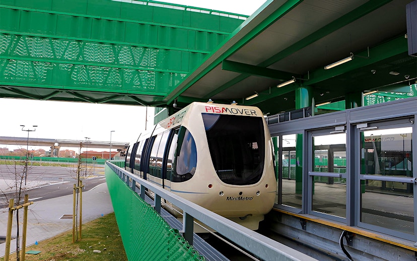 Pisamover Mini Metro at Pisa Airport terminal gate for city transfer.