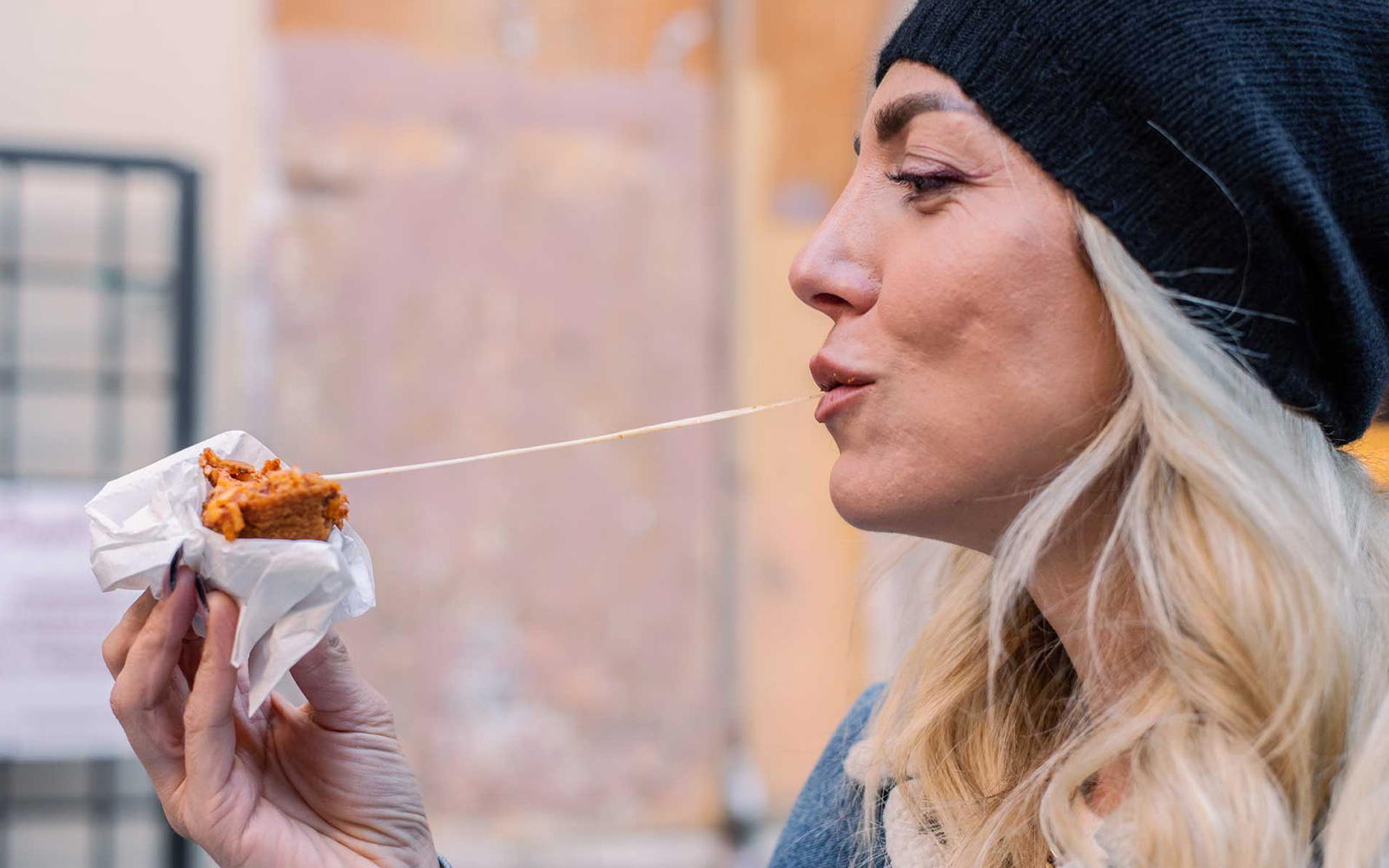 Woman enjoying a cheesy snack outdoors.