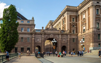 Stockholm's Parliament House with people walking, part of The Troll Escape city game.