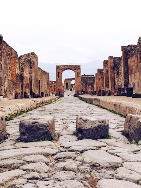 Ancient stone street leading to an archway in Pompeii, Italy.