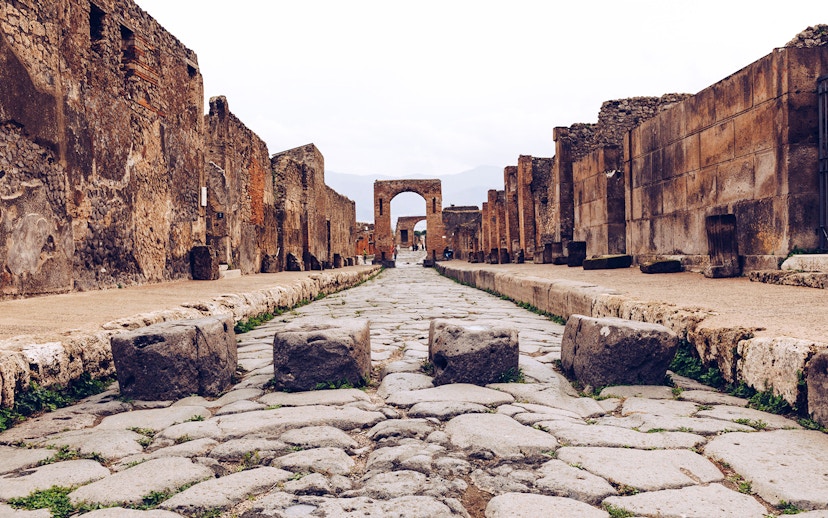 Ancient stone street leading to an archway in Pompeii, Italy.