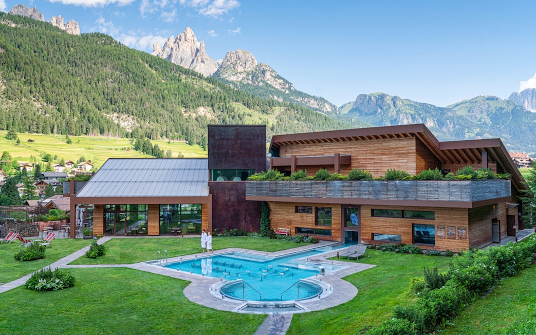 QC Terme Resort & Spa in Dolomiti with outdoor pool and mountain view.