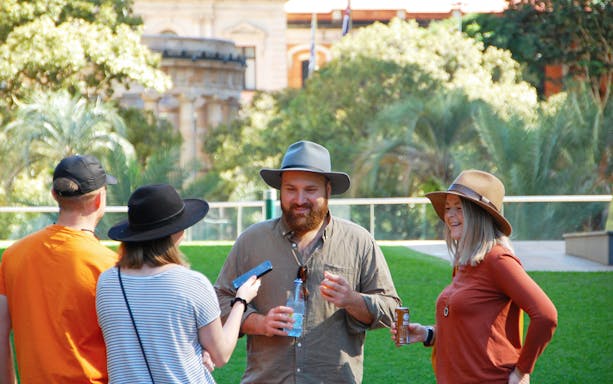 Group enjoying a walking tour in Brisbane with historic architecture in the background.