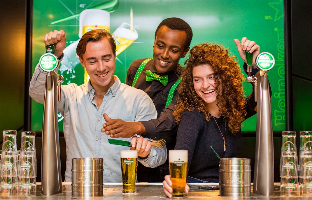 People pouring beer at Heineken brewery in Amsterdam.