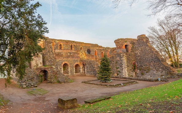 Ancient stone ruins with arches in Duesseldorf, Germany, surrounded by trees.