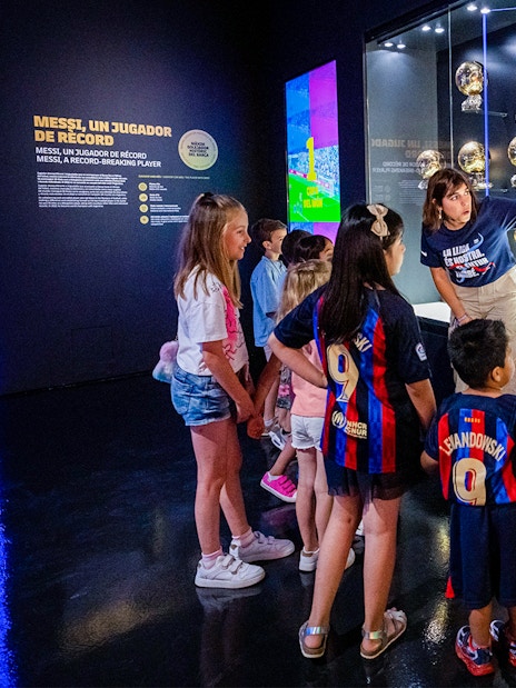 Children viewing Messi's memorabilia at Camp Nou Barca Museum during an immersive tour.