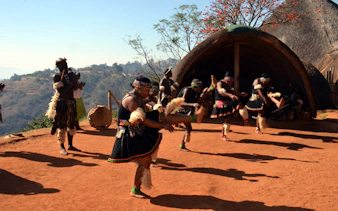 Traditional Zulu dancers performing in a village setting near Durban, South Africa.