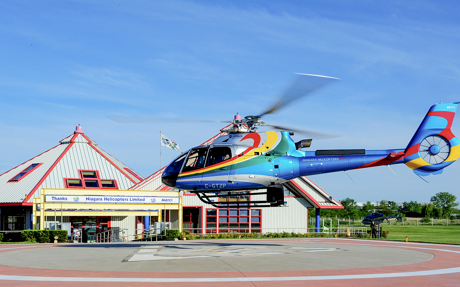 Helicopter taking off from Niagara Falls helipad for aerial tour.