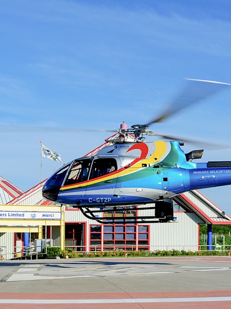 Helicopter taking off from Niagara Falls helipad for aerial tour.