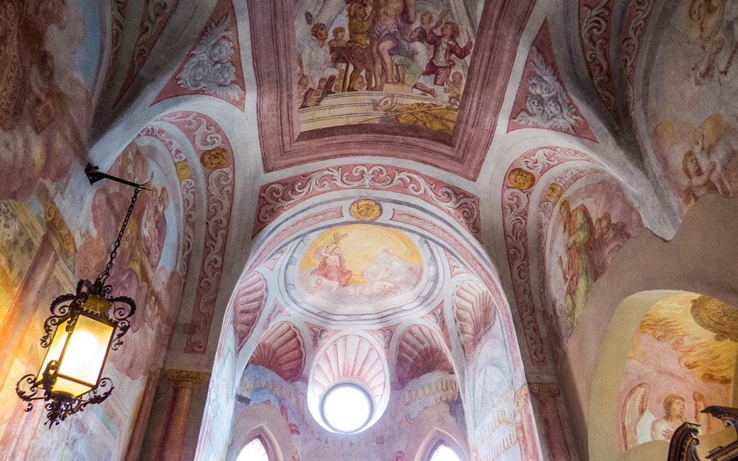 Ceiling frescoes of Bled Castle Chapel with religious scenes and ornate designs.