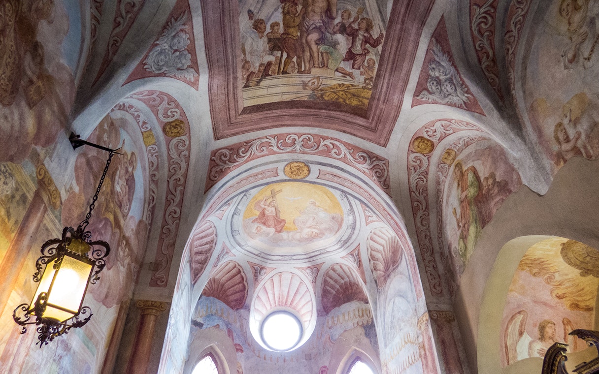 Ceiling frescoes of Bled Castle Chapel with religious scenes and ornate designs.