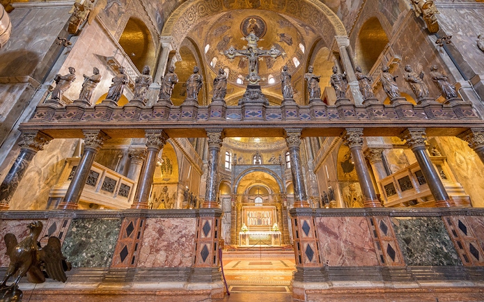 St. Mark's Basilica interior with ornate columns and statues, Venice, Italy.
