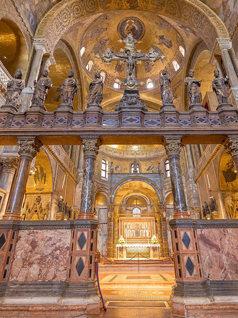 St. Mark's Basilica interior with ornate columns and statues, Venice, Italy.