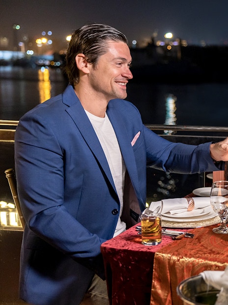 Couple toasting wine glasses on Luxury Dhow Cruise at night.