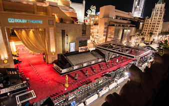 Exterior view of The Dolby Theatre in Los Angeles with red carpet setup for the Oscars.
