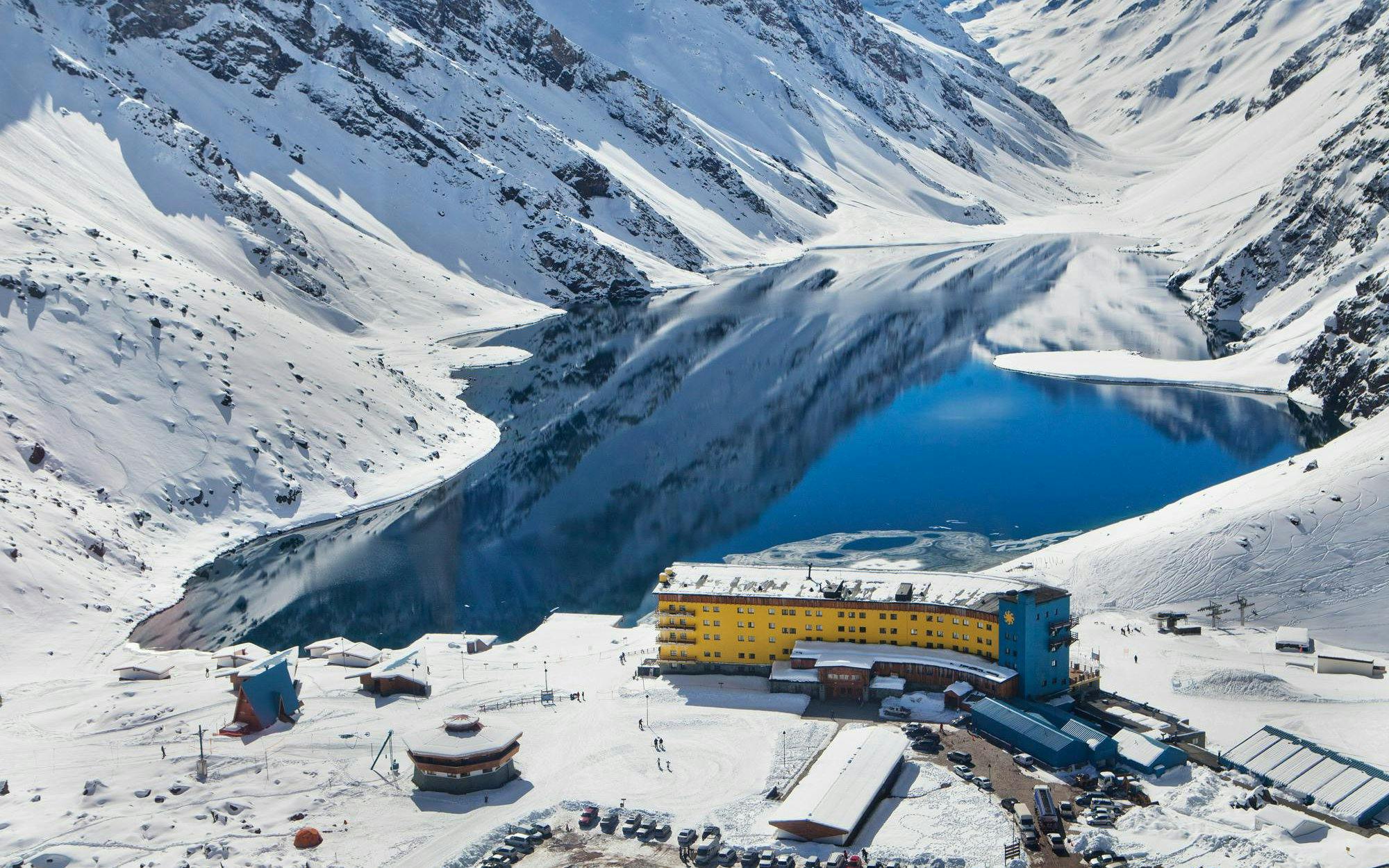 Arial view of Portillo resort with snowy mountains and a lake in Chile.