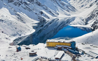 Arial view of Portillo resort with snowy mountains and a lake in Chile.