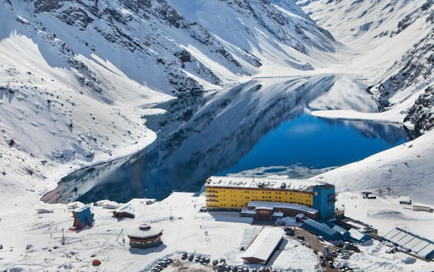 Arial view of Portillo resort with snowy mountains and a lake in Chile.