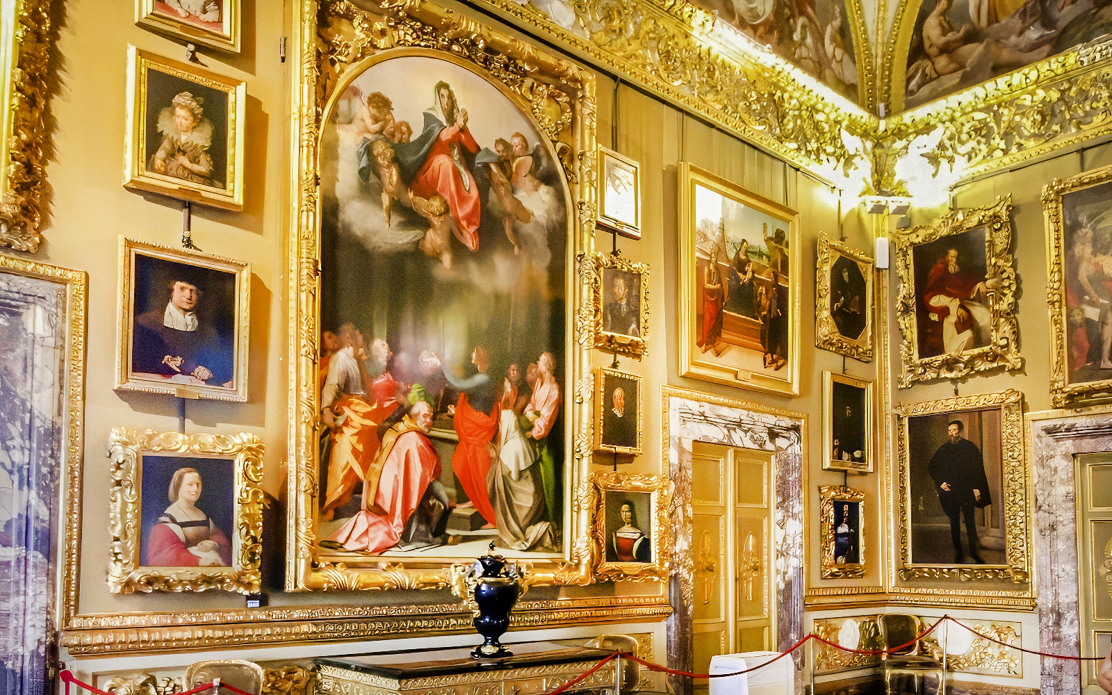 Paintings in the Palatine Gallery, Florence, featuring religious and portrait art in ornate frames.