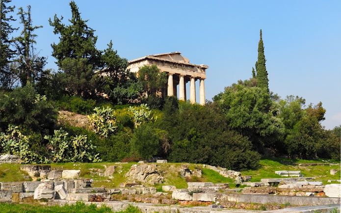 Temple of Hephaestus surrounded by greenery in Ancient Agora, Athens, Greece.