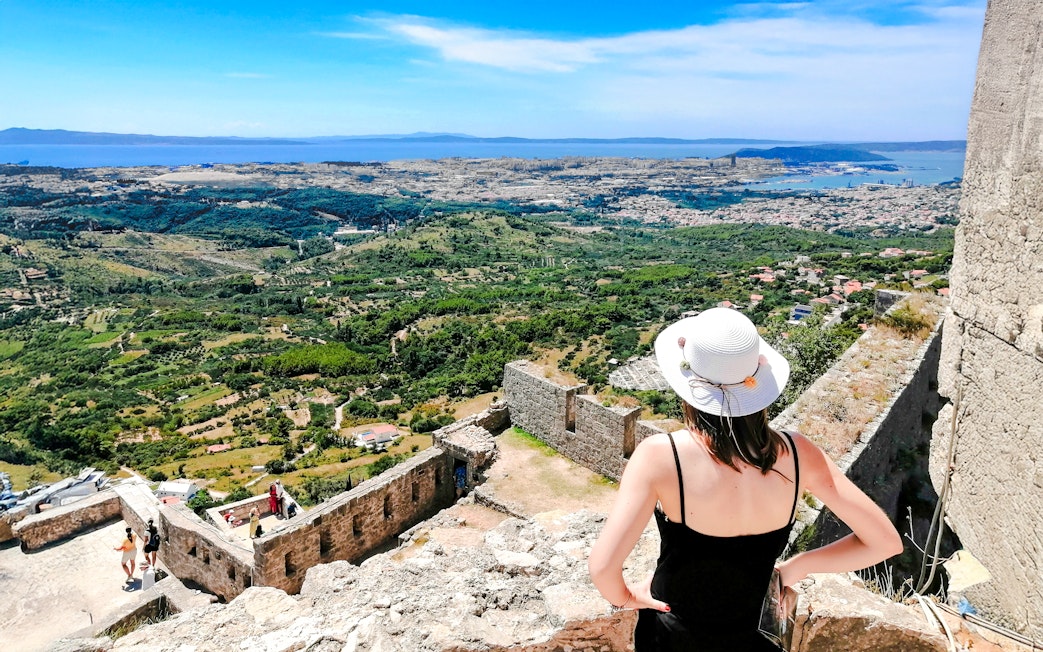 Panoramic view from Klis Fortress with tourist overlooking Split, Croatia.