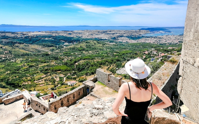 Panoramic view from Klis Fortress with tourist overlooking Split, Croatia.