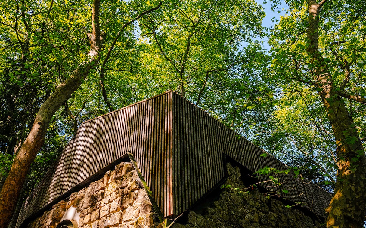 Moorish Castle ruins with Church of São Pedro de Canaferrim in Sintra, Portugal, surrounded by trees.