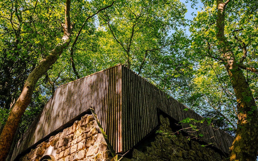 Moorish Castle ruins with Church of São Pedro de Canaferrim in Sintra, Portugal, surrounded by trees.