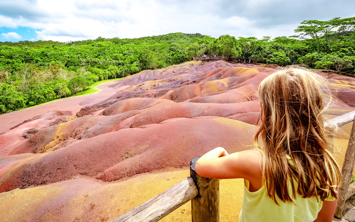 Seven Colored Earth Geopark in Chamarel, Mauritius with vibrant sand dunes and lush greenery.