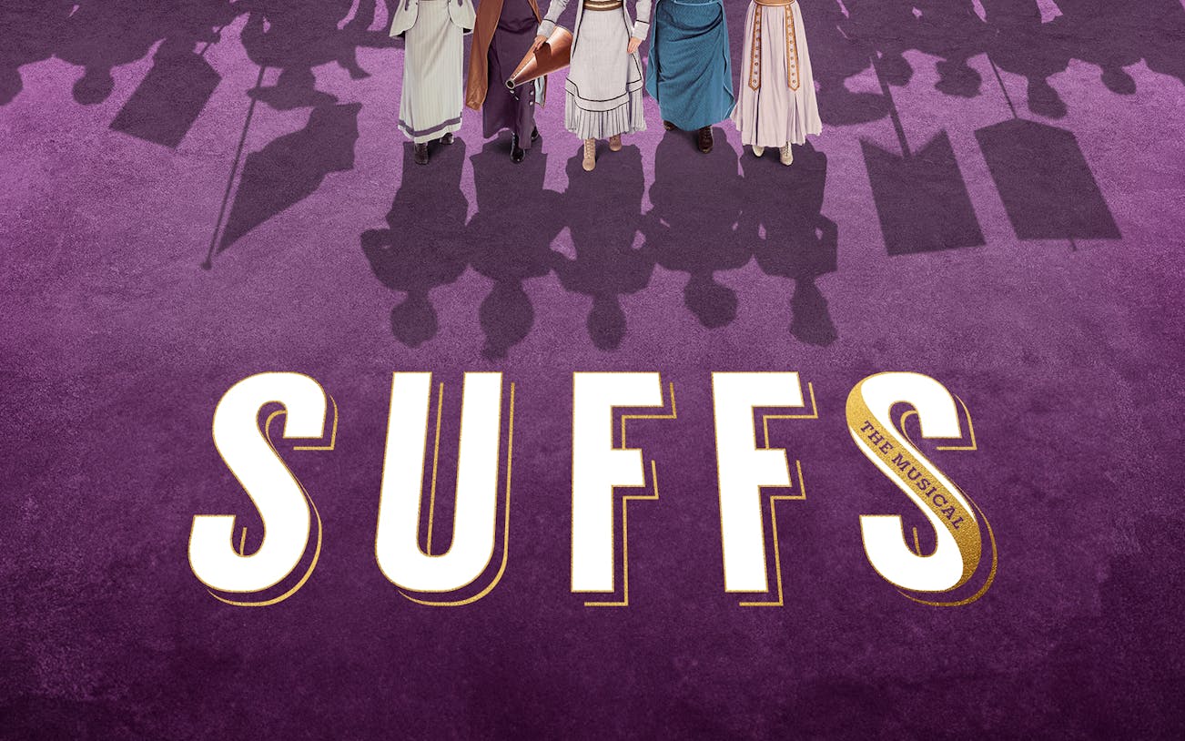 Women in period costumes with protest signs, Suffs musical promotion.