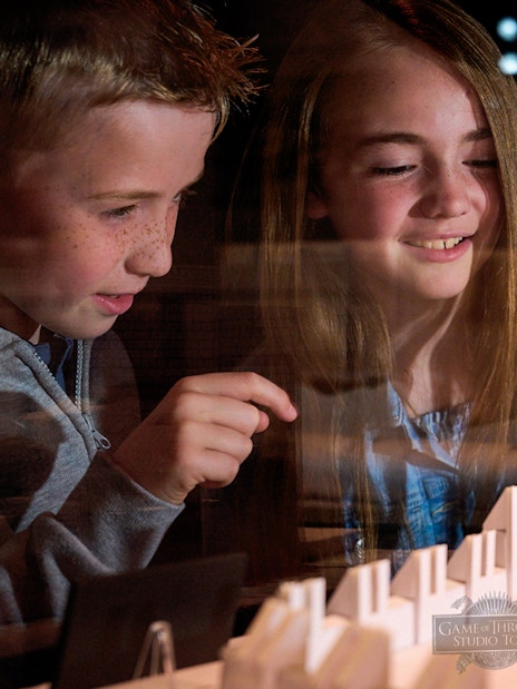 Children observing a Game of Thrones set model at the studio tour.