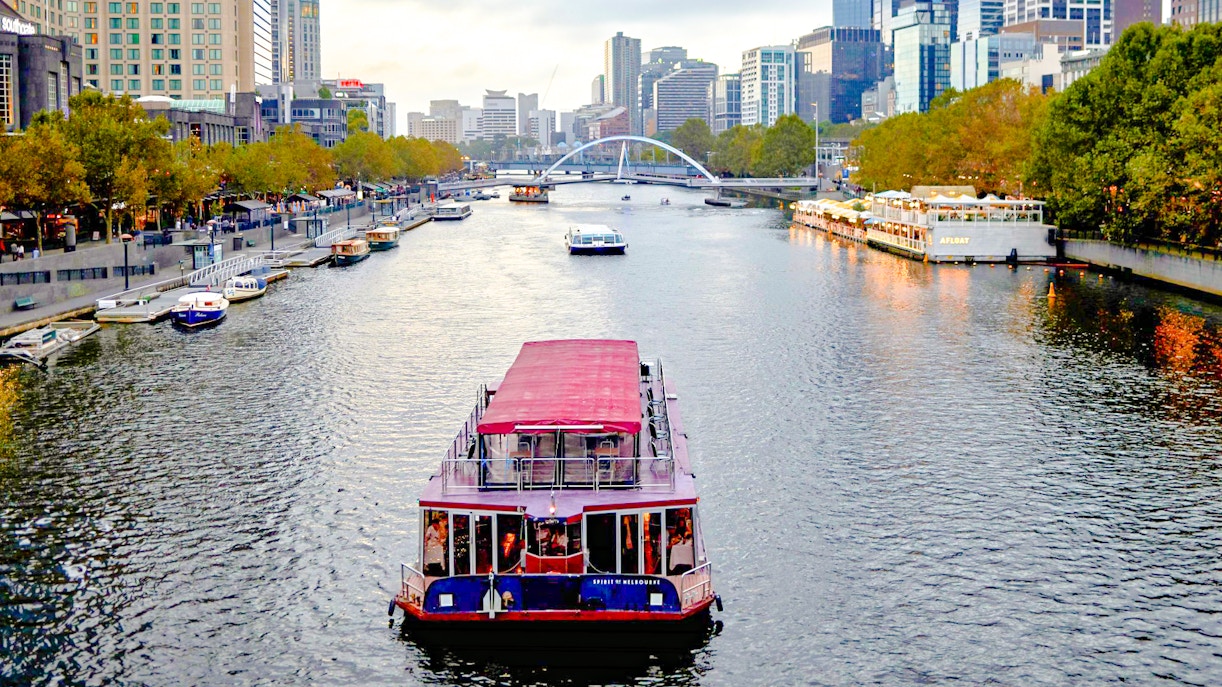 Cruise boat on Yarra River with Melbourne skyline in the background.