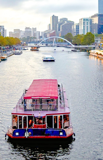 Cruise boat on Yarra River with Melbourne skyline in the background.