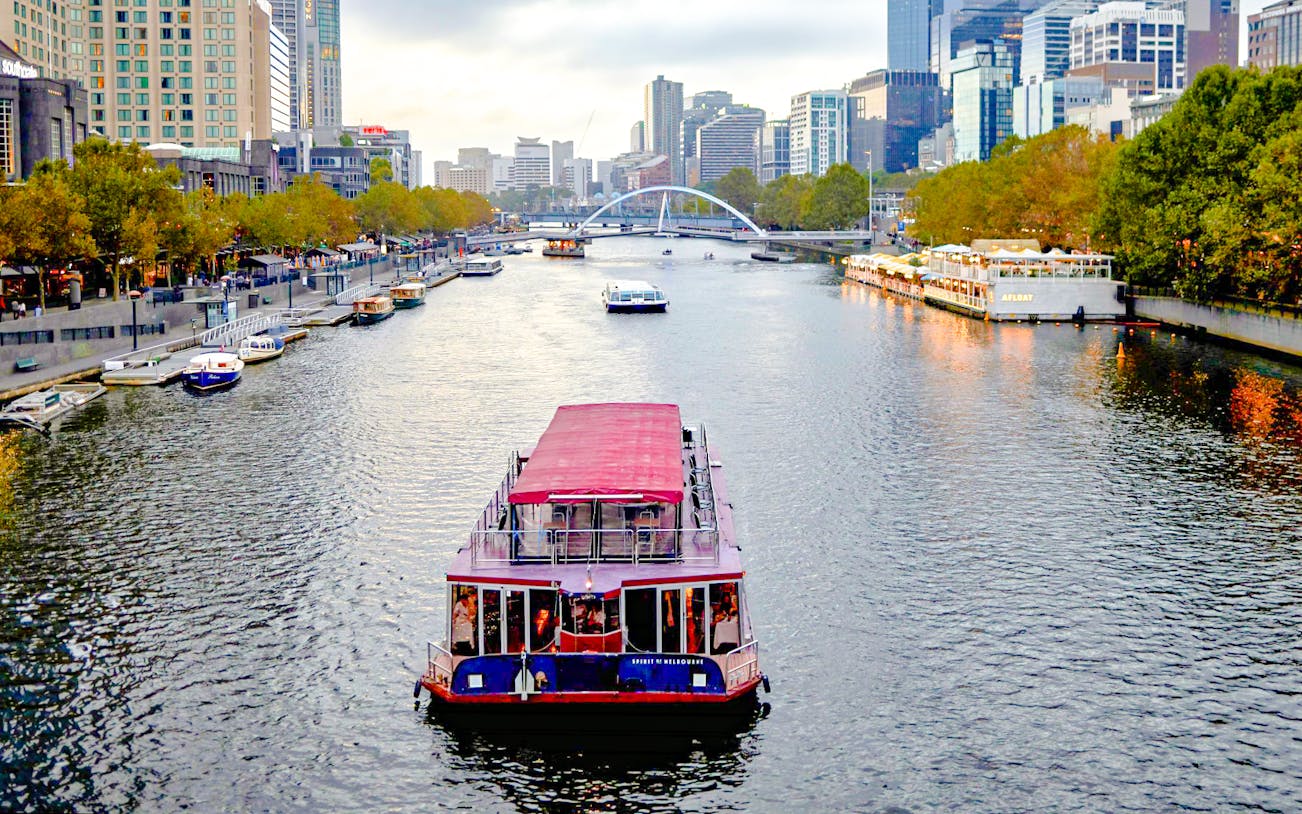 Cruise boat on Yarra River with Melbourne skyline in the background.