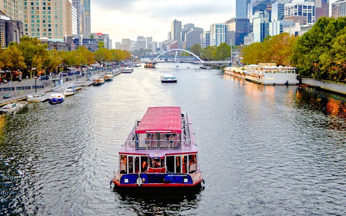Cruise boat on Yarra River with Melbourne skyline in the background.