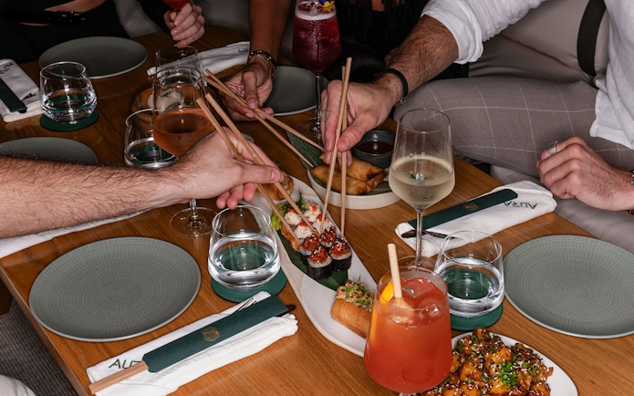 Dining experience with sushi and drinks at Aura Sky Pool.