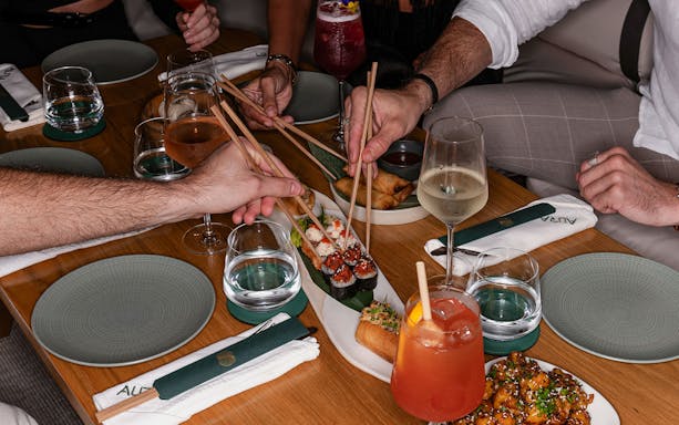 Dining experience with sushi and drinks at Aura Sky Pool.