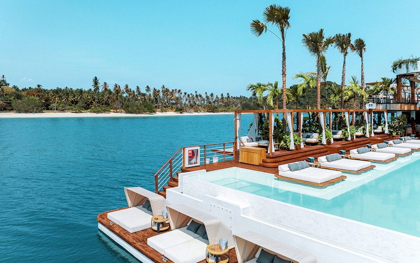 Sitting area with loungers and pool at Yona Beach Club, Phuket, overlooking the ocean.