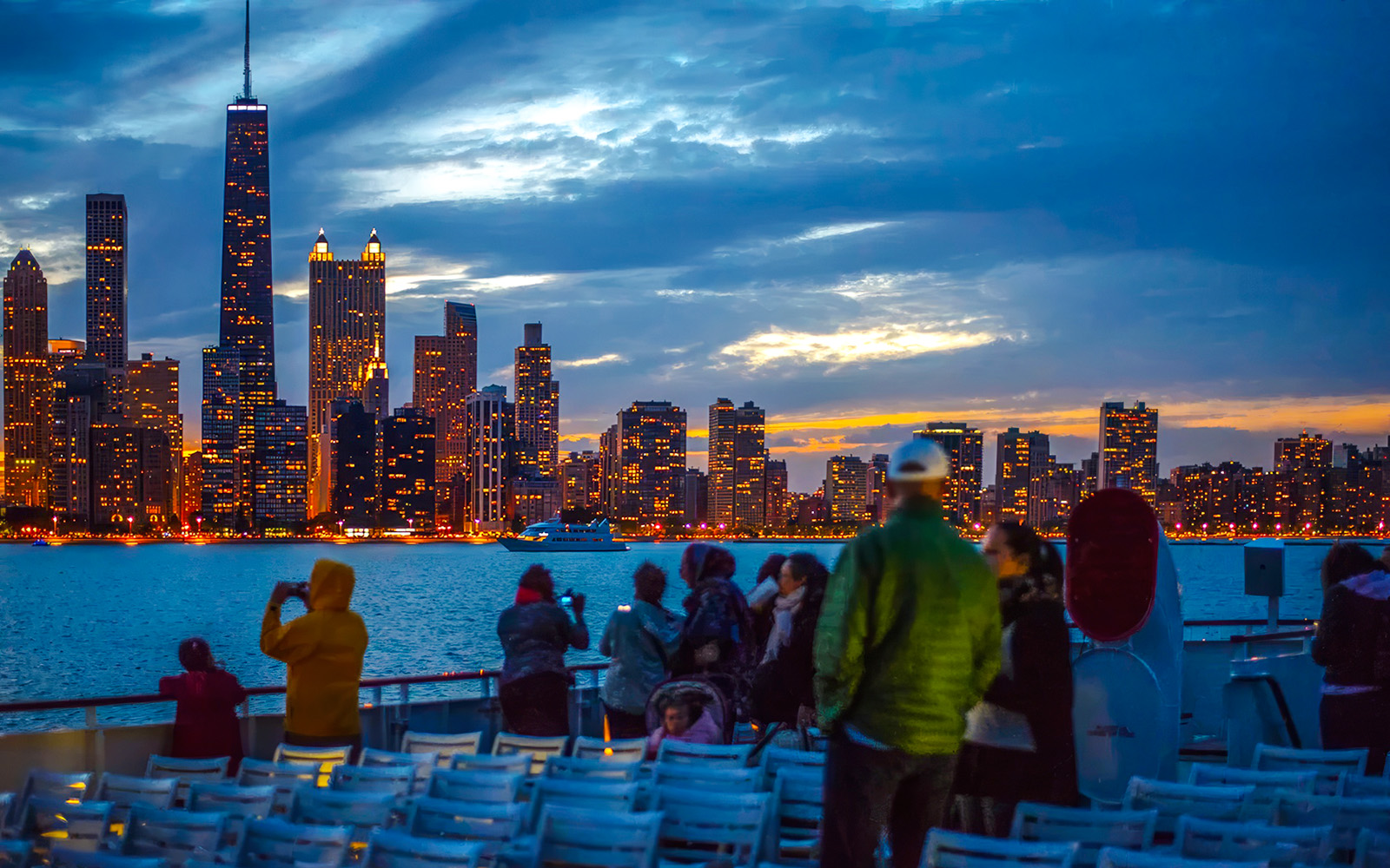 People enjoying a sunset cruise with Chicago skyline in the background.