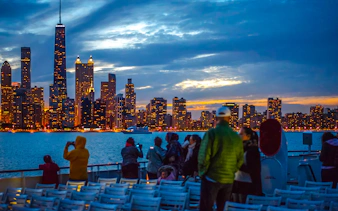 People enjoying a sunset cruise with Chicago skyline in the background.