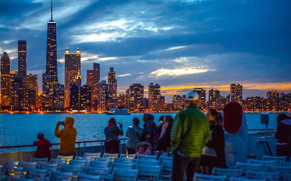 People enjoying a sunset cruise with Chicago skyline in the background.