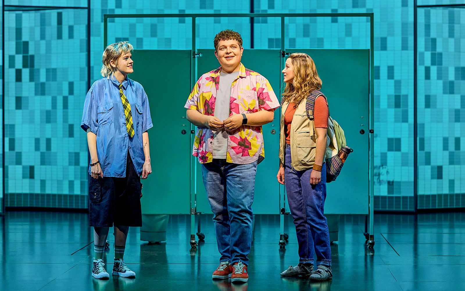 Three actors on stage in a scene from Mean Girls The Musical.