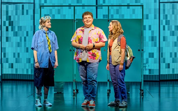 Three actors on stage in a scene from Mean Girls The Musical.