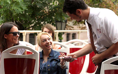 Tourists interacting with guide on Budapest Hop-On Hop-Off bus tour.