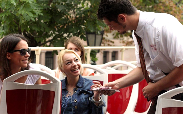 Tourists interacting with guide on Budapest Hop-On Hop-Off bus tour.