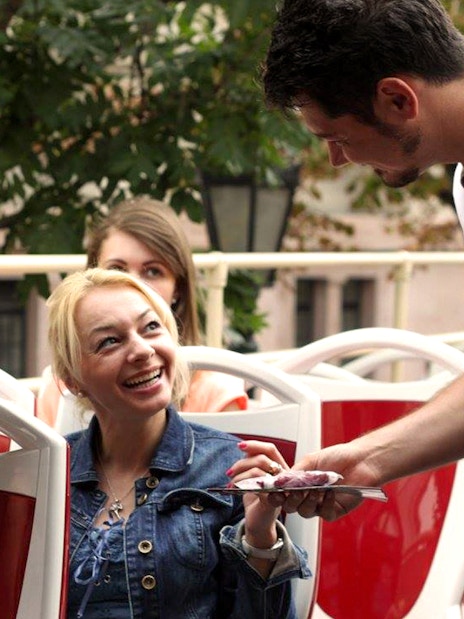 Tourists interacting with guide on Budapest Hop-On Hop-Off bus tour.