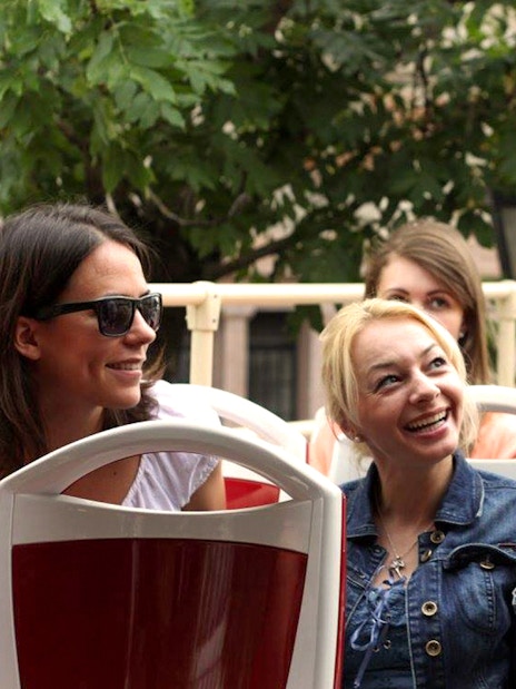 Tourists interacting with guide on Budapest Hop-On Hop-Off bus tour.